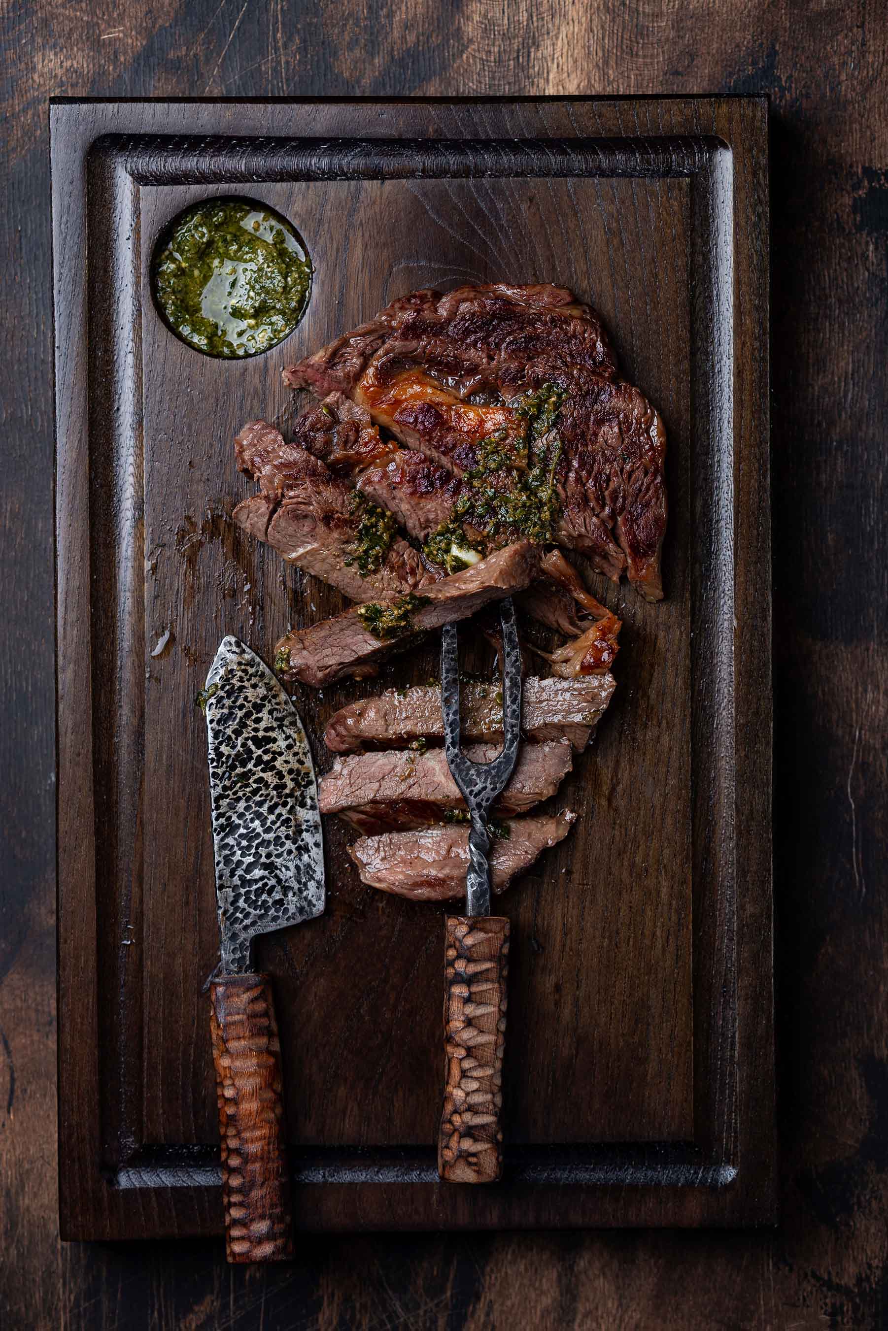 Cortes de carne apresentados sobre uma tábua escura